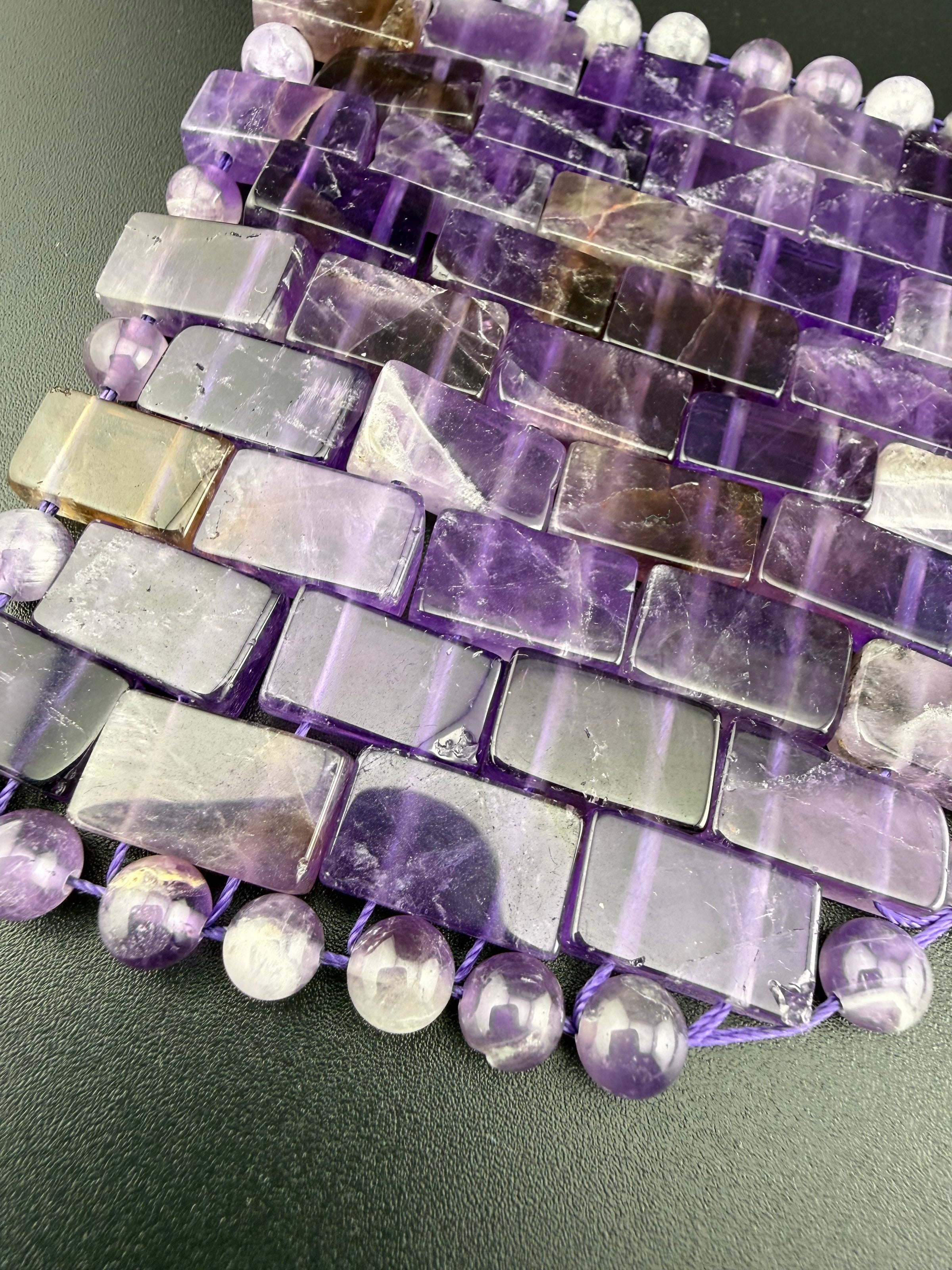 Close-up detail of a natural amethyst crystal eye mask featuring polished gemstone tiles and beads for relaxation, meditation, and luxury spa wellness.
