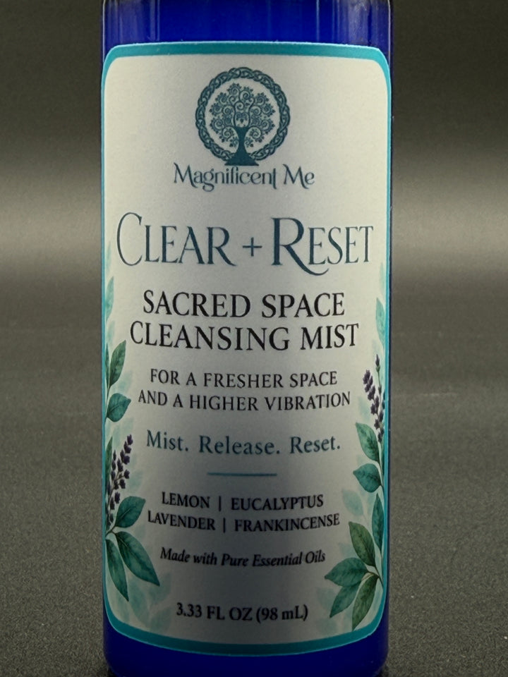 Close-up of Clear + Reset Sacred Space Cleansing Mist label showing the Magnificent Me logo and lemon, eucalyptus, lavender and frankincense essential oil blend.