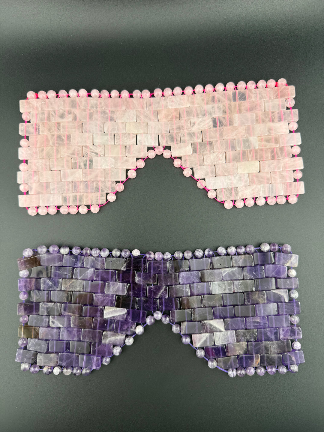 Rose quartz and amethyst crystal eye masks displayed on a dark background for cooling relaxation, meditation, spa wellness, and luxury self-care rituals.