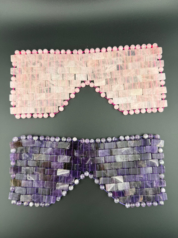 Rose quartz and amethyst crystal eye masks displayed on a dark background for cooling relaxation, meditation, spa wellness, and luxury self-care rituals.